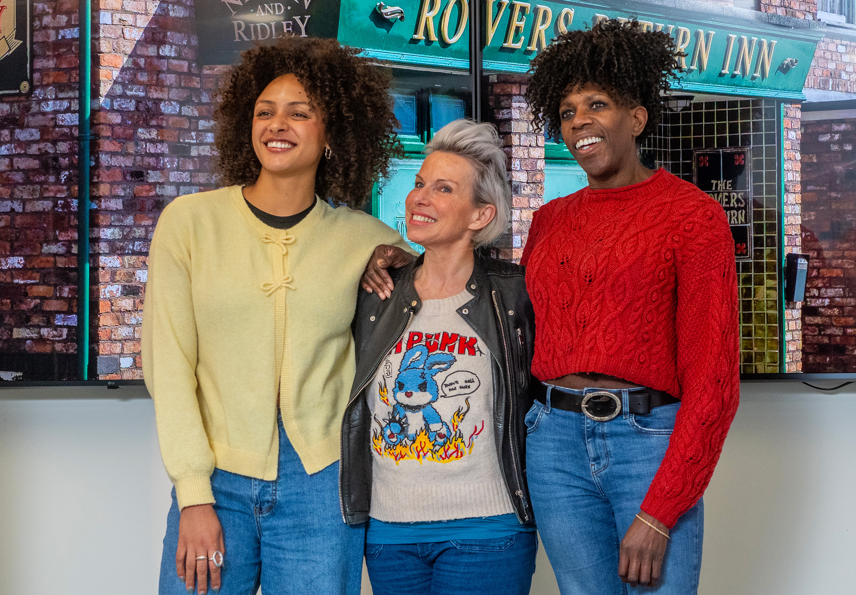A group of three friends posing together at the Coronation Street Experience in Manchester
