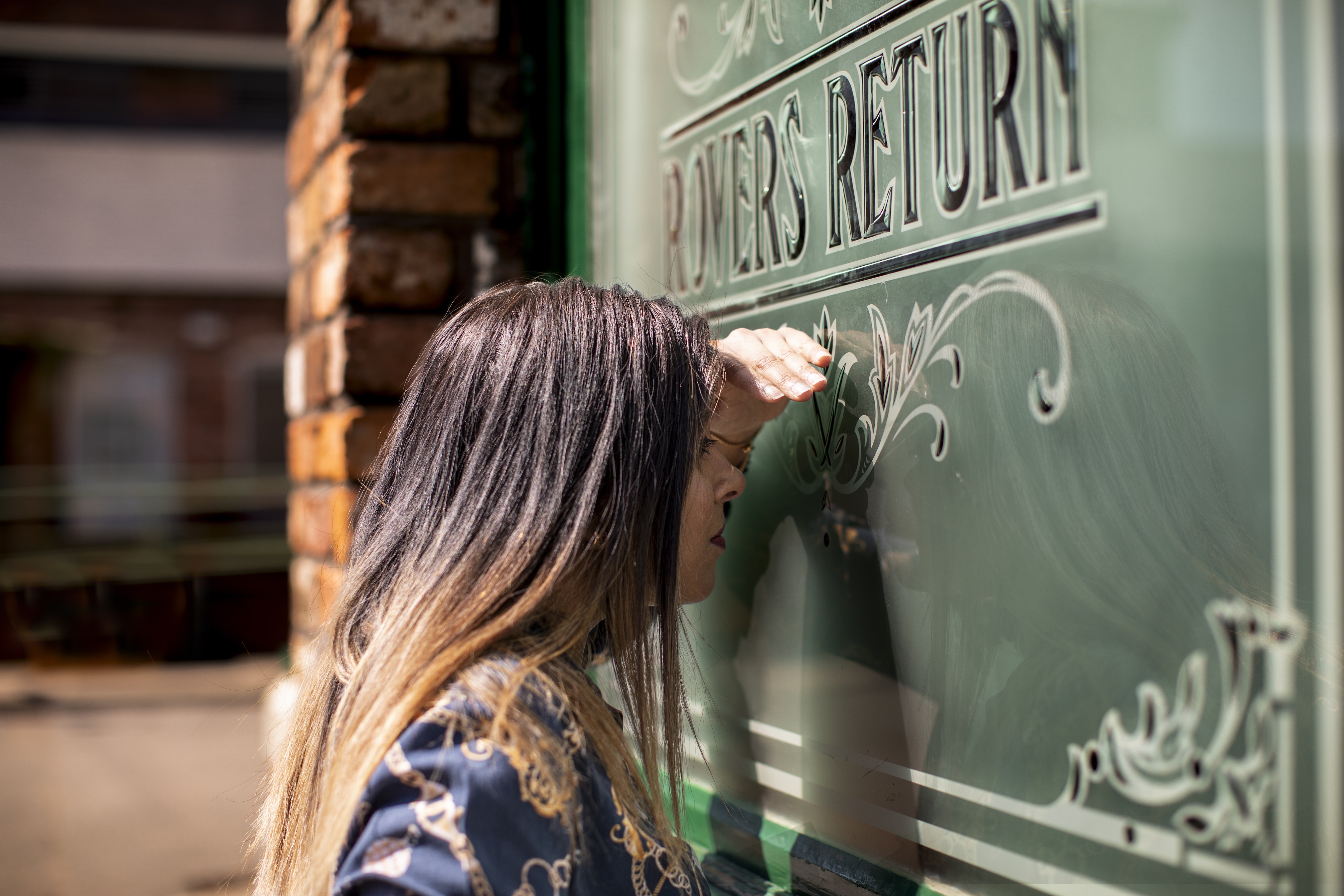 A visitor peeking through the Rovers Return Inn at the Coronation Street Experience